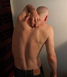 Man scratching his back