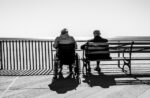 Aging couple, on a bench and in a wheelchair